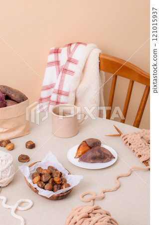 Sweet potatoes and chestnuts, perfect for snacking while knitting, are plated on the table. Sweet potatoes and chestnuts, perfect for snacking while knitting, are plated on the table. 121015937