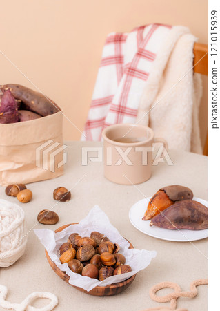 Sweet potatoes and chestnuts, perfect for snacking while knitting, are plated on the table. Sweet potatoes and chestnuts, perfect for snacking while knitting, are plated on the table. 121015939