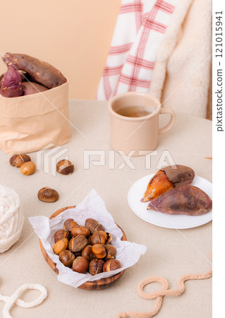 Sweet potatoes and chestnuts, perfect for snacking while knitting, are plated on the table. 121015941