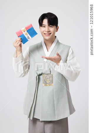 Portrait of a young man wearing hanbok and holding a luxury gift certificate 121015968