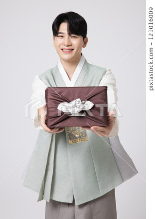 A young man wearing a hanbok and holding a carefully prepared holiday gift 121016009