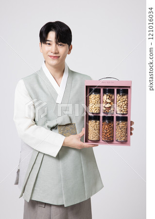 Portrait of a young man wearing hanbok and opening a gift box Portrait of a young man wearing hanbok and opening a gift box 121016034