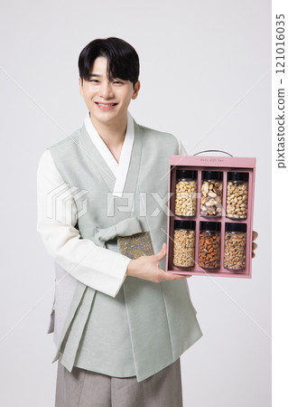 Portrait of a young man wearing hanbok and opening a gift box Portrait of a young man wearing hanbok and opening a gift box 121016035