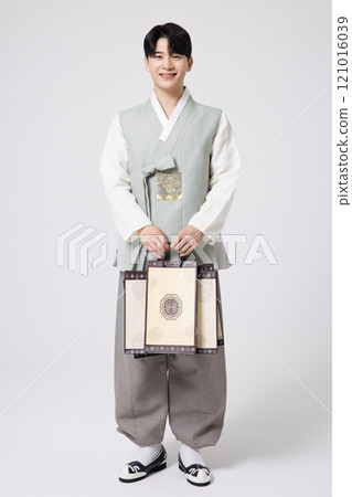 Portrait of a young man wearing hanbok and holding shopping bags Portrait of a young man wearing hanbok and holding shopping bags 121016039