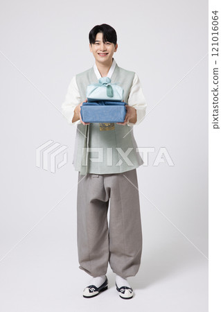 Portrait of a young man wearing hanbok and holding a luxurious holiday gift Portrait of a young man wearing hanbok and holding a luxurious holiday gift 121016064