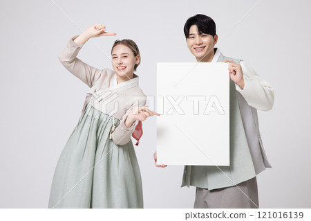 A foreign woman and a Korean man wearing hanbok, standing side by side and holding white copyspace 121016139