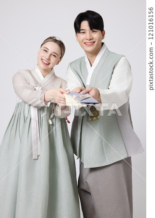 A foreign woman and a Korean man wearing hanbok and holding a gift certificate 121016156