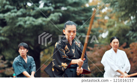 Martial arts, park and instructor with wood sword for fight, battle and samurai training class. Woods, ninja and mentor with bamboo weapon, kendo and warrior in autumn in Japan with fighter group 121016157