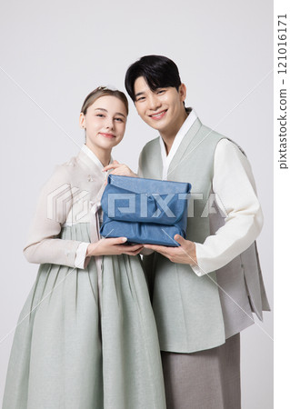 A foreign woman and a Korean man wearing hanbok and holding carefully prepared gifts A foreign woman and a Korean man wearing hanbok and holding carefully prepared gifts 121016171