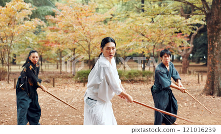 Martial arts, students and instructor outdoor with wood sword for fight, battle and samurai training class. Park, ninja and mentor with weapon, kendo and warrior in autumn in Japan with fighter group 121016239