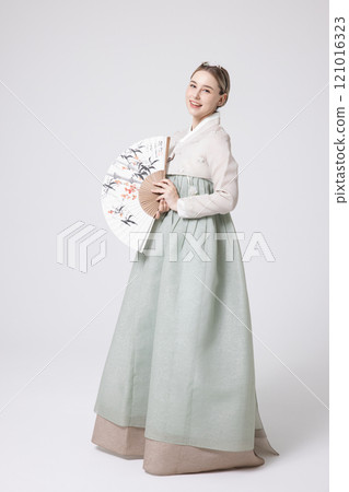 A foreign woman wearing a traditional Korean hanbok and holding a fan 121016323