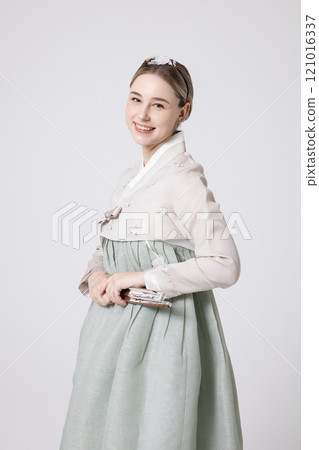 A foreign woman wearing a traditional Korean hanbok and holding a fan 121016337