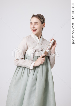 A foreign woman wearing a traditional Korean hanbok and holding a fan 121016340