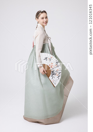 A foreign woman wearing a traditional Korean hanbok and holding a fan 121016345