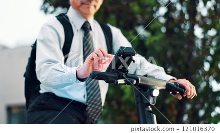 Businessman, phone or hands on electrical bike in city for travel, clean energy or sustainable transport. Commute, ride or eco friendly scooter with mobile app in street for location or map in Japan Businessman, phone or hands on electrical bike in city for travel, clean energy or sustainable transport. Commute, ride or eco friendly scooter with mobile app in street for location or map in Japan 121016370
