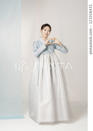 A beautiful woman standing and making a heart shape with her hands wearing an elegant and elegant hanbok A beautiful woman standing and making a heart shape with her hands wearing an elegant and elegant hanbok 121016431