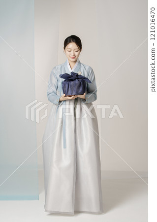 Portrait of a beautiful woman standing holding a holiday gift wearing an elegant and elegant hanbok Portrait of a beautiful woman standing holding a holiday gift wearing an elegant and elegant hanbok 121016470
