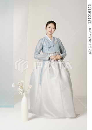 Beautiful woman wearing luxurious and elegant hanbok standing next to a vase Beautiful woman wearing luxurious and elegant hanbok standing next to a vase 121016566