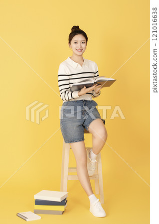 A college student wearing casual clothes and reading A college student wearing casual clothes and reading 121016638