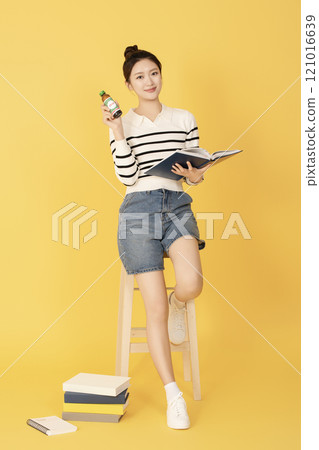 A college student wearing casual clothes and reading A college student wearing casual clothes and reading 121016639
