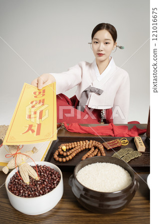 A shaman wearing a hanbok and giving an amulet 121016675