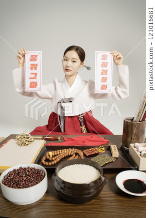 A shaman sitting wearing a hanbok and holding an amulet A shaman sitting wearing a hanbok and holding an amulet 121016681