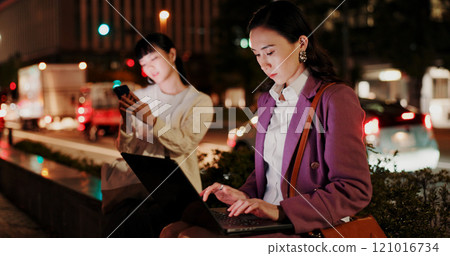 Night, woman and laptop in city for business, research deadline and connectivity in Yokohama. Japanese workaholic, typing or computer on dark sidewalk for late work, commitment or networking at bokeh 121016734