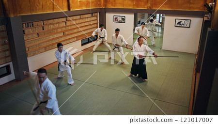 Dojo, group class and Aikido training with wood sword Japanese martial arts and fight exercise in wellness studio. Learning, master and bamboo weapon with people and strike practice for defence 121017007