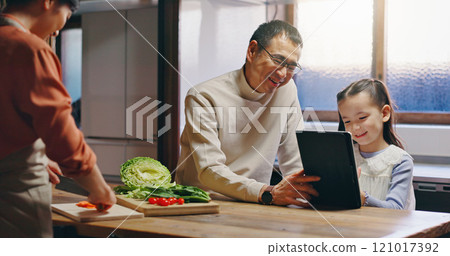 Dad, girl and tablet in kitchen with mother, cooking and happy with streaming, video or movie in family home. People, father and child with digital touchscreen for cartoon movies at house in Japan 121017392