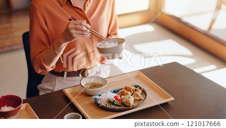Woman, hands or eating rice with chopsticks at dinner table for meal, snack or cuisine at home. Closeup, Japan or female person tasting with bowl or utensils for dining culture, tradition or heritage Woman, hands or eating rice with chopsticks at dinner table for meal, snack or cuisine at home. Closeup, Japan or female person tasting with bowl or utensils for dining culture, tradition or heritage 121017666