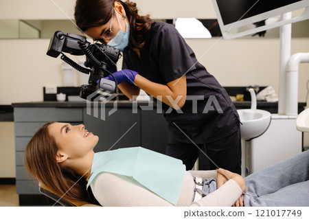 Dentist woman photographing with professional camera the result of her work in clinic 121017749