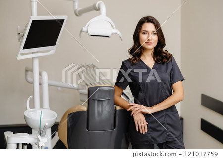 Smiling female dentist looking at the camera in dental clinic Smiling female dentist looking at the camera in dental clinic 121017759