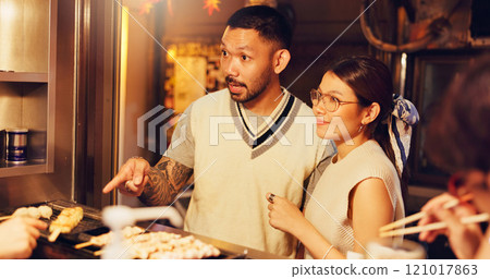 Street food, night and shopping of Japanese couple at market for culture festive, nutrition or health. Travel, hunger and cuisine with man and woman at Japan city vendor for date and holiday 121017863