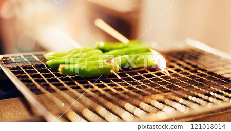 Japanese, food and green vegetable skewer on grill, outdoor barbecue or traditional kebab dinner on fire. Asian cuisine, culture and cooking pepper kushiyaki cooking on flames at local street market. 121018014