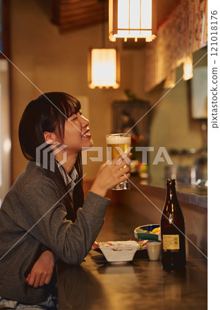 A woman drinking beer with relish. Photo courtesy of Osado Tamura. 121018176