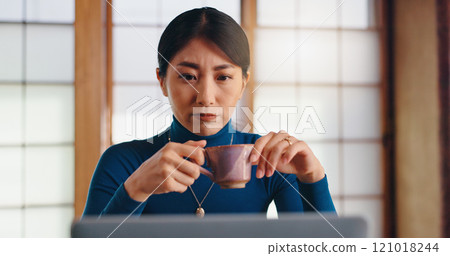Laptop, tea or Asian woman in home office reading for remote work, research or website. Coffee, author or creative freelancer drinking beverage for campaign, editing or publishing review in Japan 121018244
