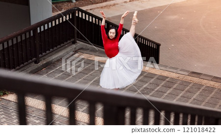 Woman, stretching and ballet movement in city, outdoor and practice performance for art. Female person, professional dancer and creative talent in Japan, rehearsal and urban town for elegant training 121018422