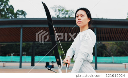 Serious, athlete and woman with bow, sport and practice for challenge, training and equipment for game. Outdoor, skills and talent for archery, shooting and arrow for competition, archer and Japan Serious, athlete and woman with bow, sport and practice for challenge, training and equipment for game. Outdoor, skills and talent for archery, shooting and arrow for competition, archer and Japan 121019024