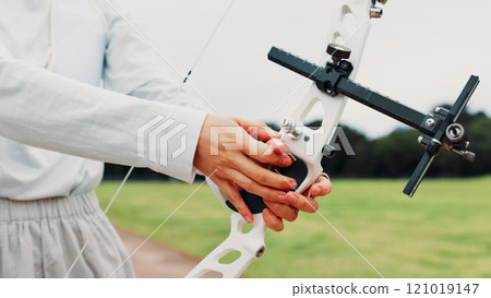 Person, archery and hands at field for sport at shooting practice and training as athlete in Japan. Closeup, target and setup recurve bow or equipment for challenge, tournament and competition 121019147