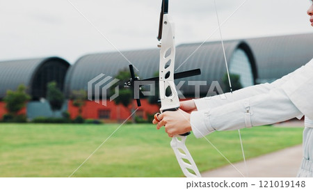 Woman, hands and prepare bow for archery training at academy, outdoor exercise and aim. Female person, shooting challenge and field for competition games, learning and practice with tool in japan Woman, hands and prepare bow for archery training at academy, outdoor exercise and aim. Female person, shooting challenge and field for competition games, learning and practice with tool in japan 121019148