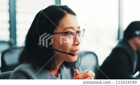 Woman, telemarketing operator and customer support agent in office, talking and advisor to client. Female person, call centre representative and helping consumer with loan in Japan insurance agency 121019149