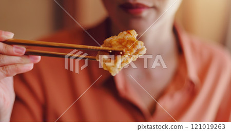 Person, hands or chopsticks with chicken for bite, eating or hungry snack for healthy meal or protein at home. Japan, closeup or food with wooden or bamboo utensils for tradition, culture or heritage 121019263