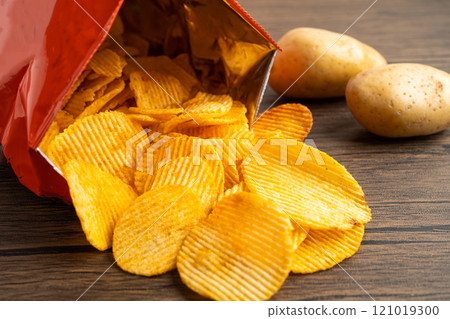 Potato chips, delicious BBQ seasoning spicy for crips, thin slice deep fried snack fast food in open bag. Potato chips, delicious BBQ seasoning spicy for crips, thin slice deep fried snack fast food in open bag. 121019300