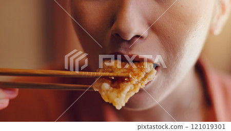 Person, mouth or bite with chopsticks for eating, hungry snack or taste for delicious meal or protein at home. Japan, closeup or food with wooden or bamboo utensils for tradition, culture or heritage 121019301
