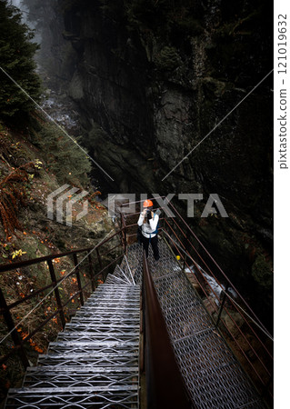 Embarking on an Adventurous Descent in a Foggy Canyon filled with Mystery and Beauty 121019632