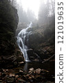 A Majestic Waterfall cascading through a Misty Forest Setting full of natural beauty and charm 121019635