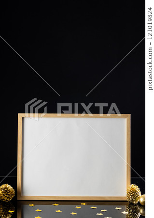 Vertical image of christmas decorations and white frame with copy space on black background 121019824
