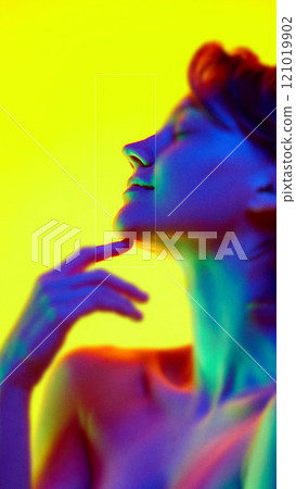 Contemporary art collage. Neon hues surround female face, with eye and cheekbone in crisp focus. Communication and social issues concept. 121019902