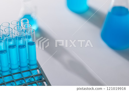 Close up of laboratory test tubes with blue liquid and copy space on white background Close up of laboratory test tubes with blue liquid and copy space on white background 121019916