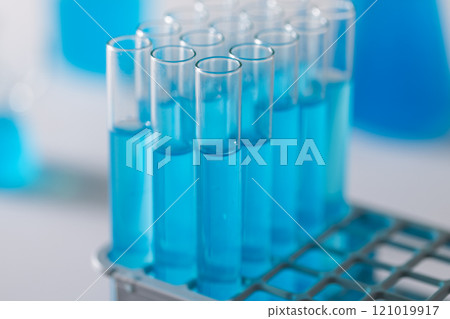 Close up of laboratory test tubes with blue liquid and copy space on white background Close up of laboratory test tubes with blue liquid and copy space on white background 121019917